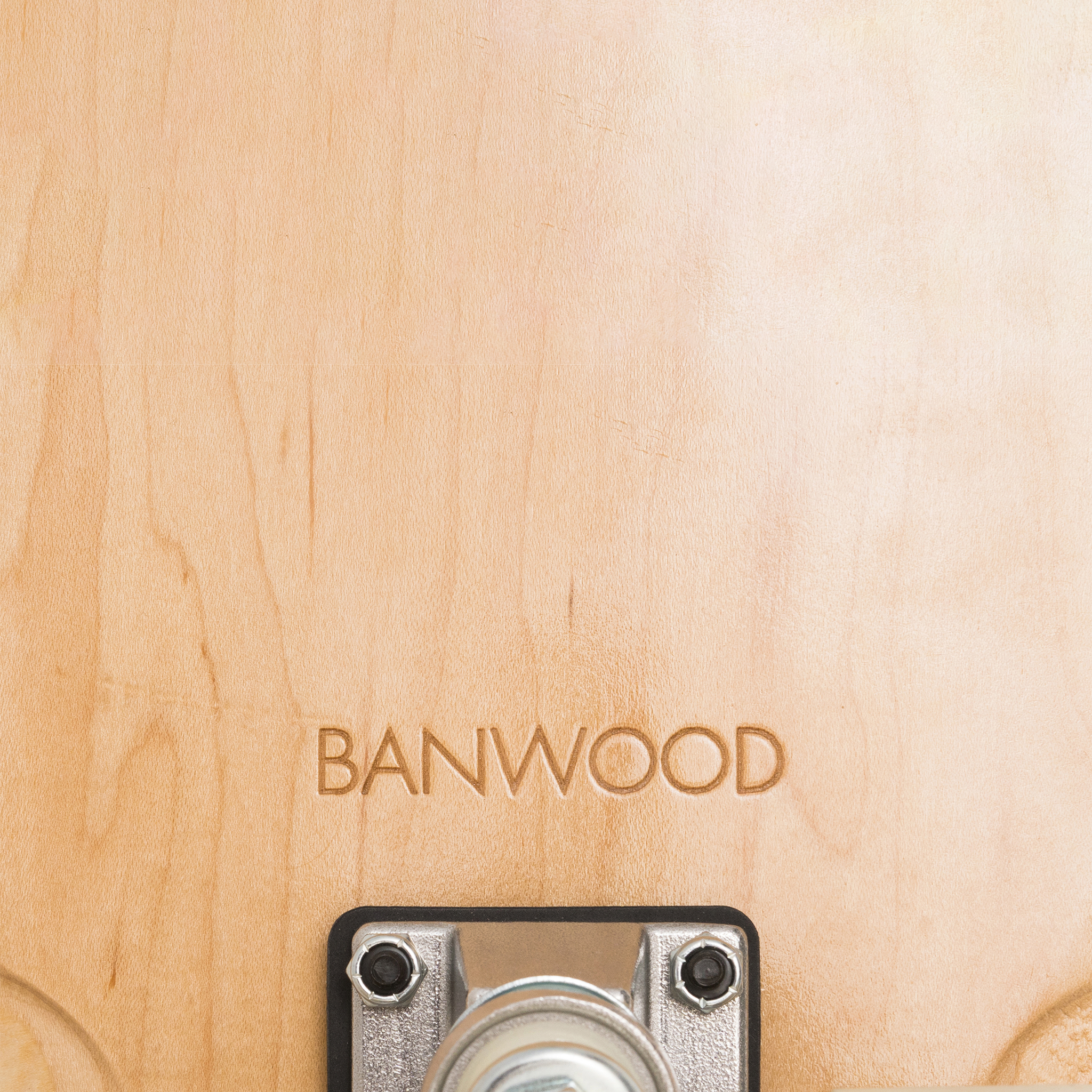 Close-up of a Canadian maple board with "BANWOOD" engraved, part of the Banwood - Skateboard Green. It features a metal component with a wheel, showcasing its high rebound wheels and light finish with visible grain patterns.