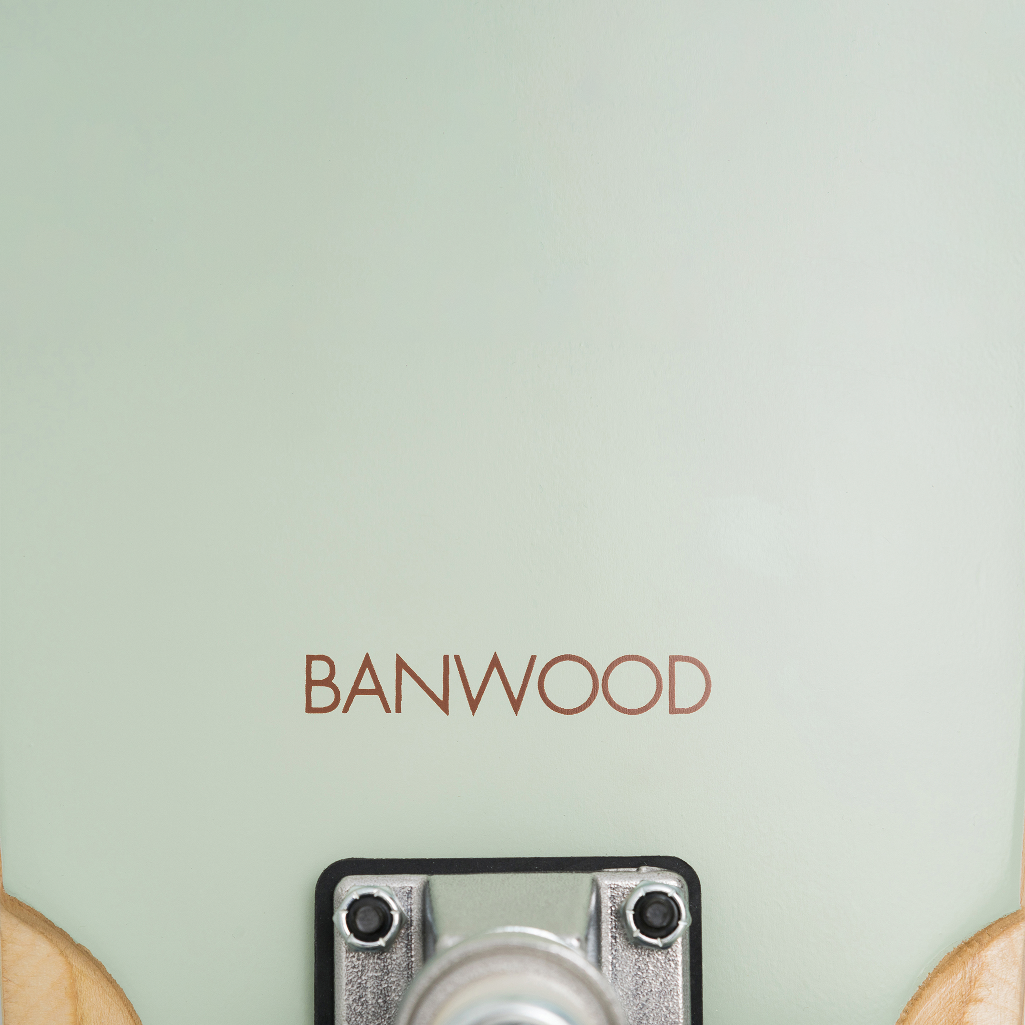 A close-up of the Banwood Skateboard Pale Mint deck shows "BANWOOD" in brown lettering. Made from quality Canadian Maple, its vintage style is highlighted by the metal base of the trucks peeking out at the bottom.
