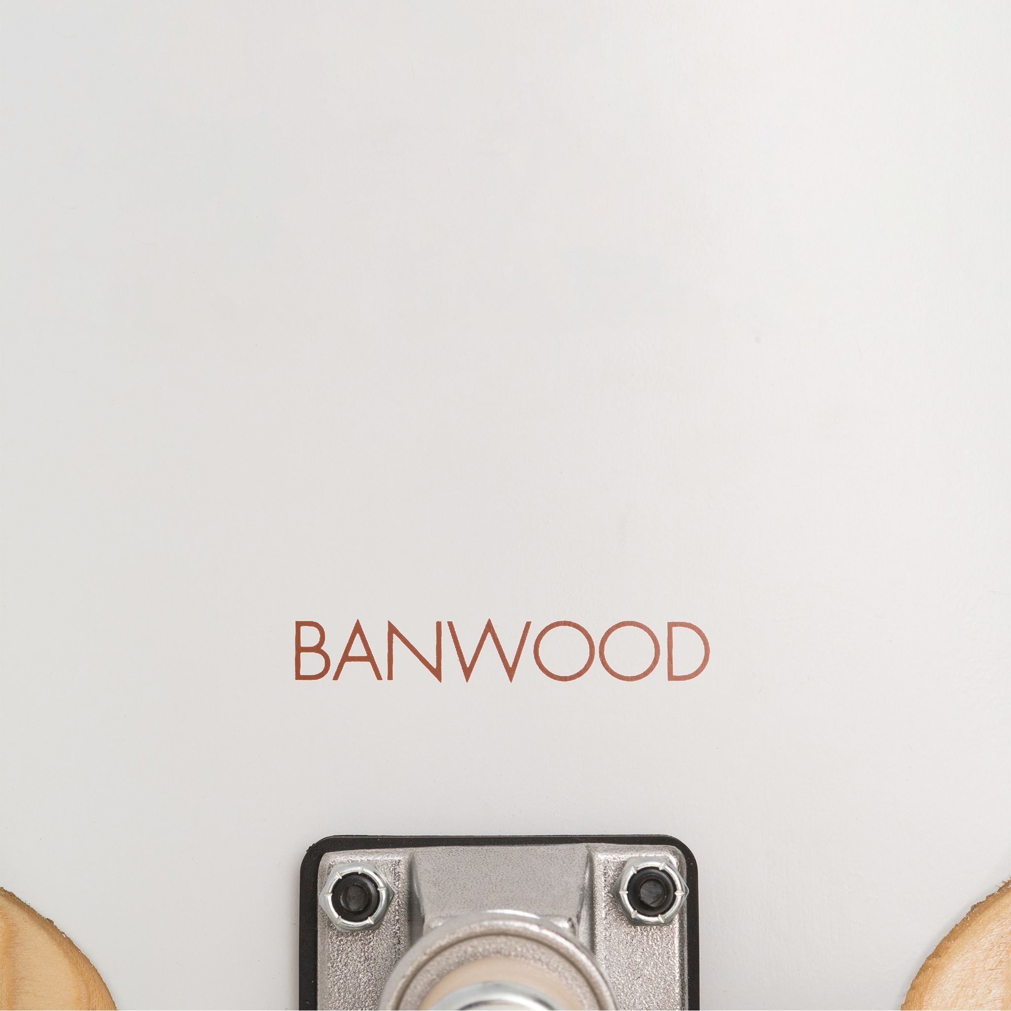 A close-up of the Banwood - Skateboard White highlights the "BANWOOD" branding in red on its white surface, offering a vintage touch. The strong metal truck with bolt and nut showcases its sturdy Canadian Maple build.