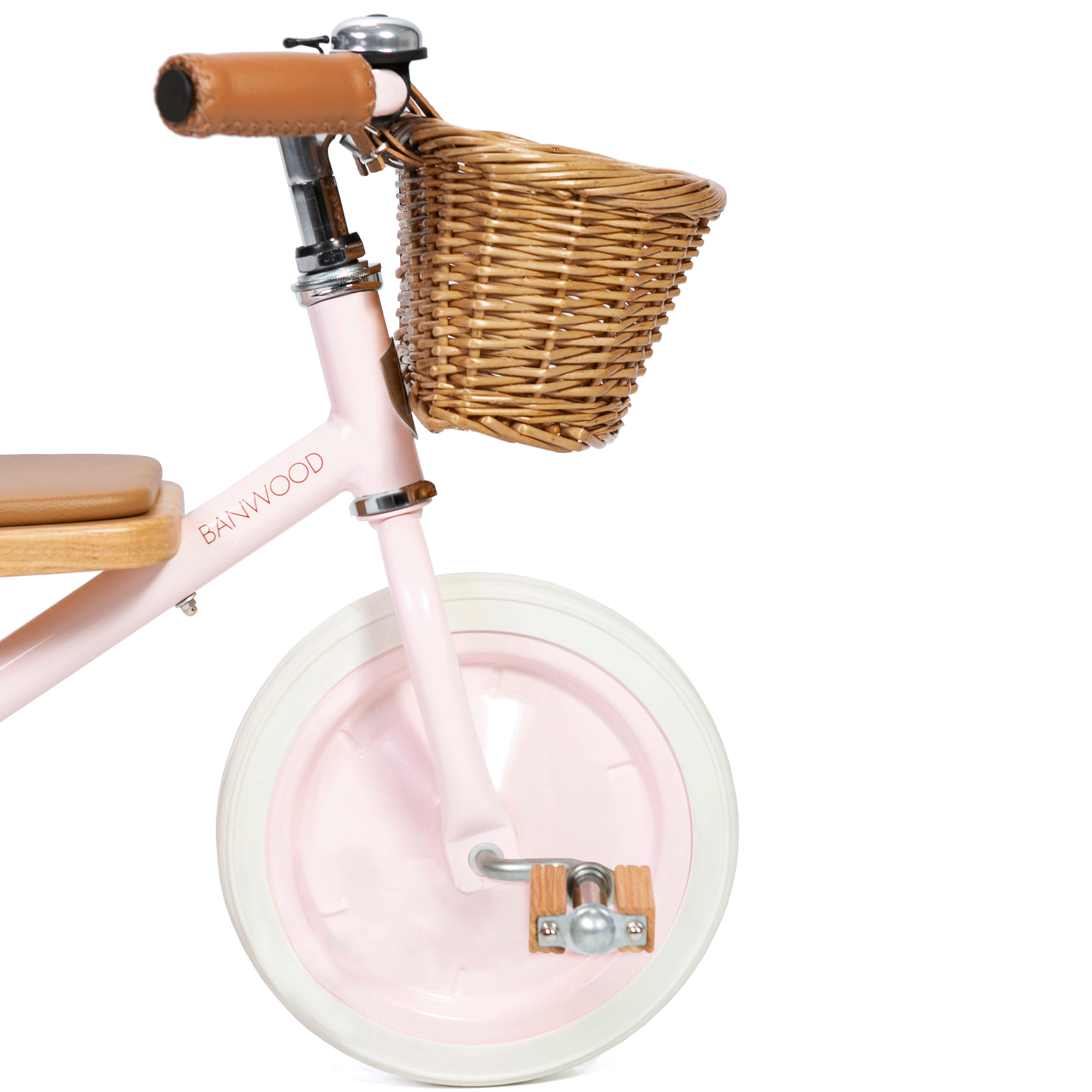 The Banwood - Trike Pink by BANWOOD showcases a pastel pink design with a wicker basket, white tires, light brown leather handlebar grips, and a wooden seat—ideal for kids who appreciate charm and style.