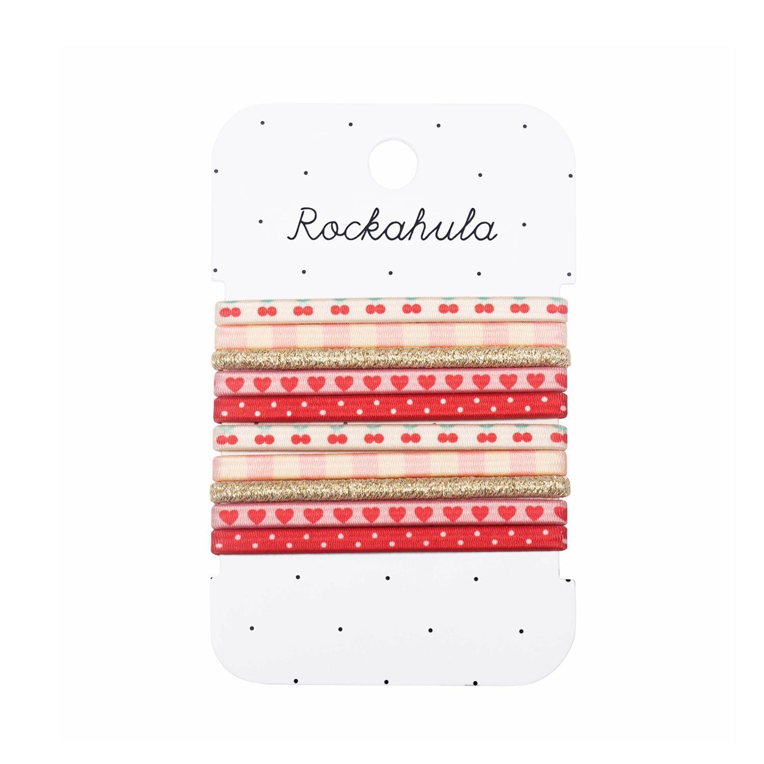 The ROCKAHULA Very Cherry Elastic Pony Pack features six red, cream, and gold hair accessories with heart, polka dot, and glitter designs, all displayed on a white card with black dots.