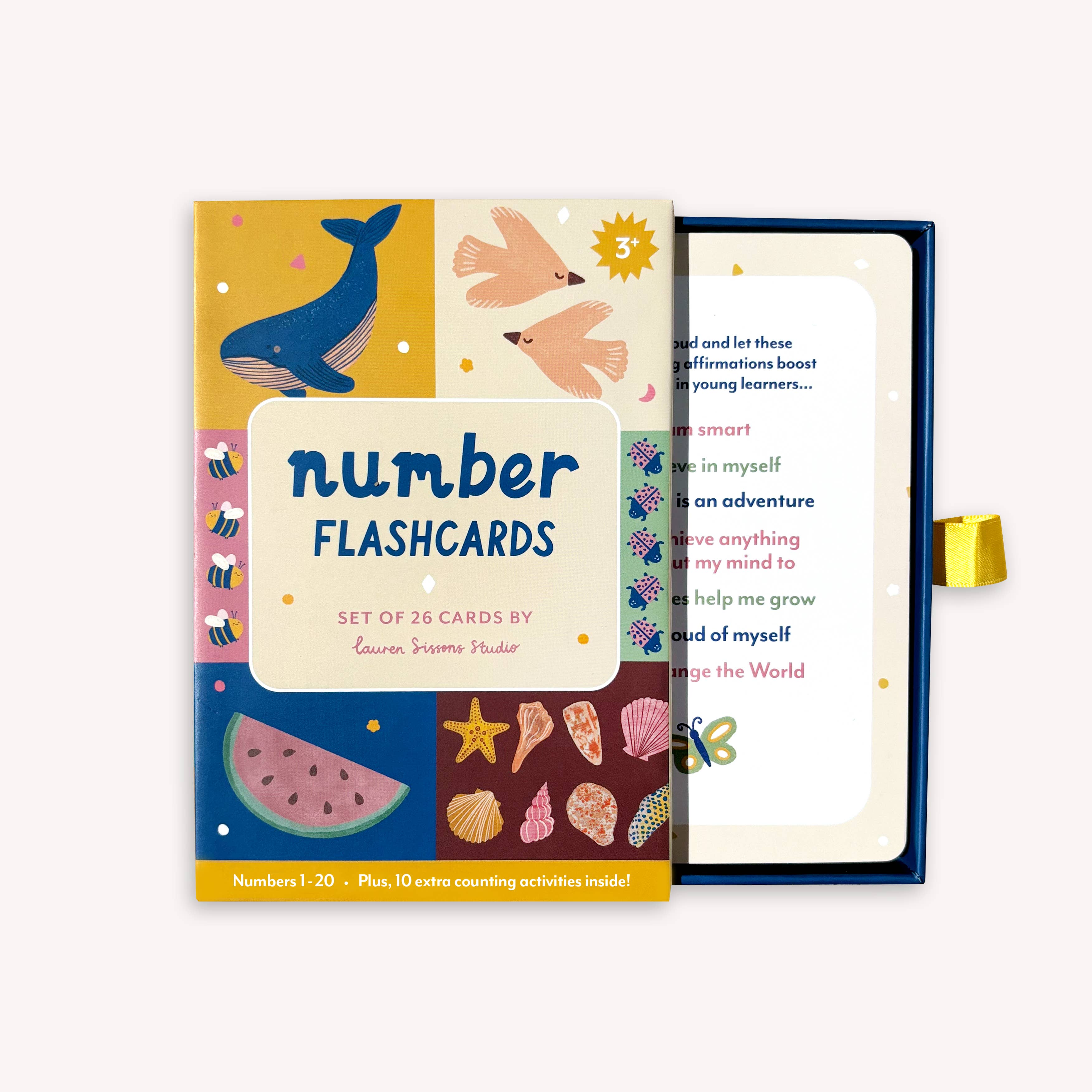 A colorful box of Lauren Sissons - Illustrated Number Flashcards by Lauren Sissons Studio, partially open to reveal playful number cards featuring whales, birds, watermelon, shells, and stars—perfect for building counting skills.