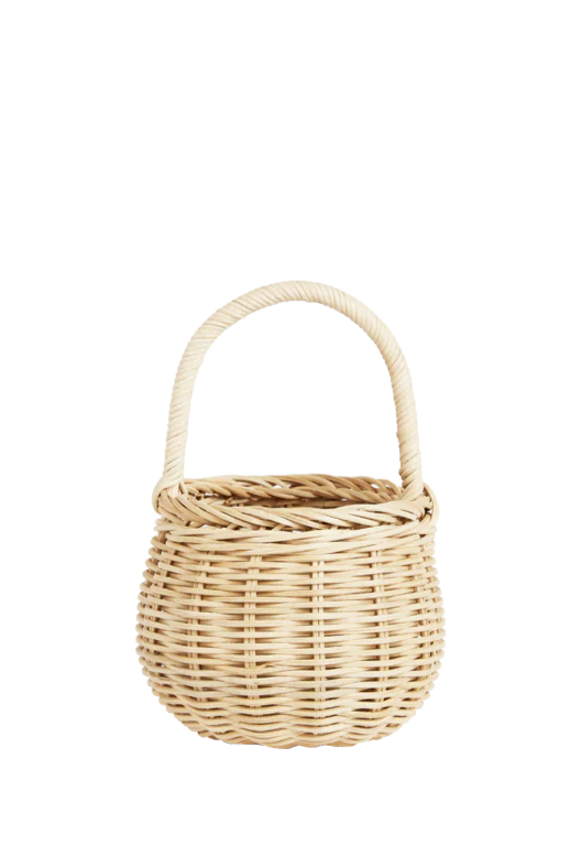 The OLLI ELLA Berry Basket Straw is a round wicker basket with a sturdy handle and natural rattan hue, featuring a tightly woven pattern that exudes rustic, handmade charm reminiscent of traditional berry baskets, standing upright against a plain white background.