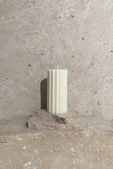 Wiggle pillar candle cream on travertine stack
