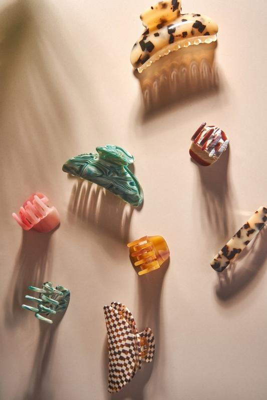 colourful hair clips on a white background with sun cashing shadows