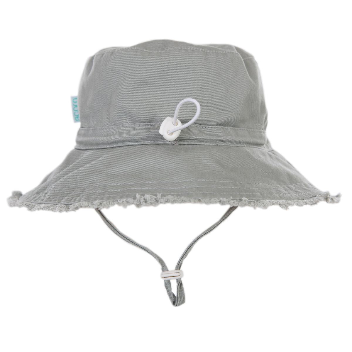 The Acorn Kids - Frayed Bucket Hat Khaki by ACORN KIDS features a wide brim, frayed edges, UPF50+ sun protection, adjustable chin strap, and a small white toggle at the front.