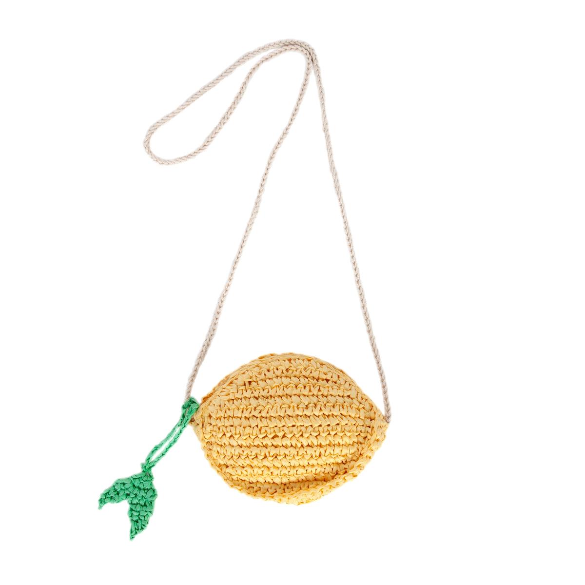 The Acorn Kids - Ravello Lemon Straw Bag by ACORN KIDS is a small, round yellow bag with a green leaf detail and long beige strap—an adorable summer accessory for sunny outings. Displayed on a white background.