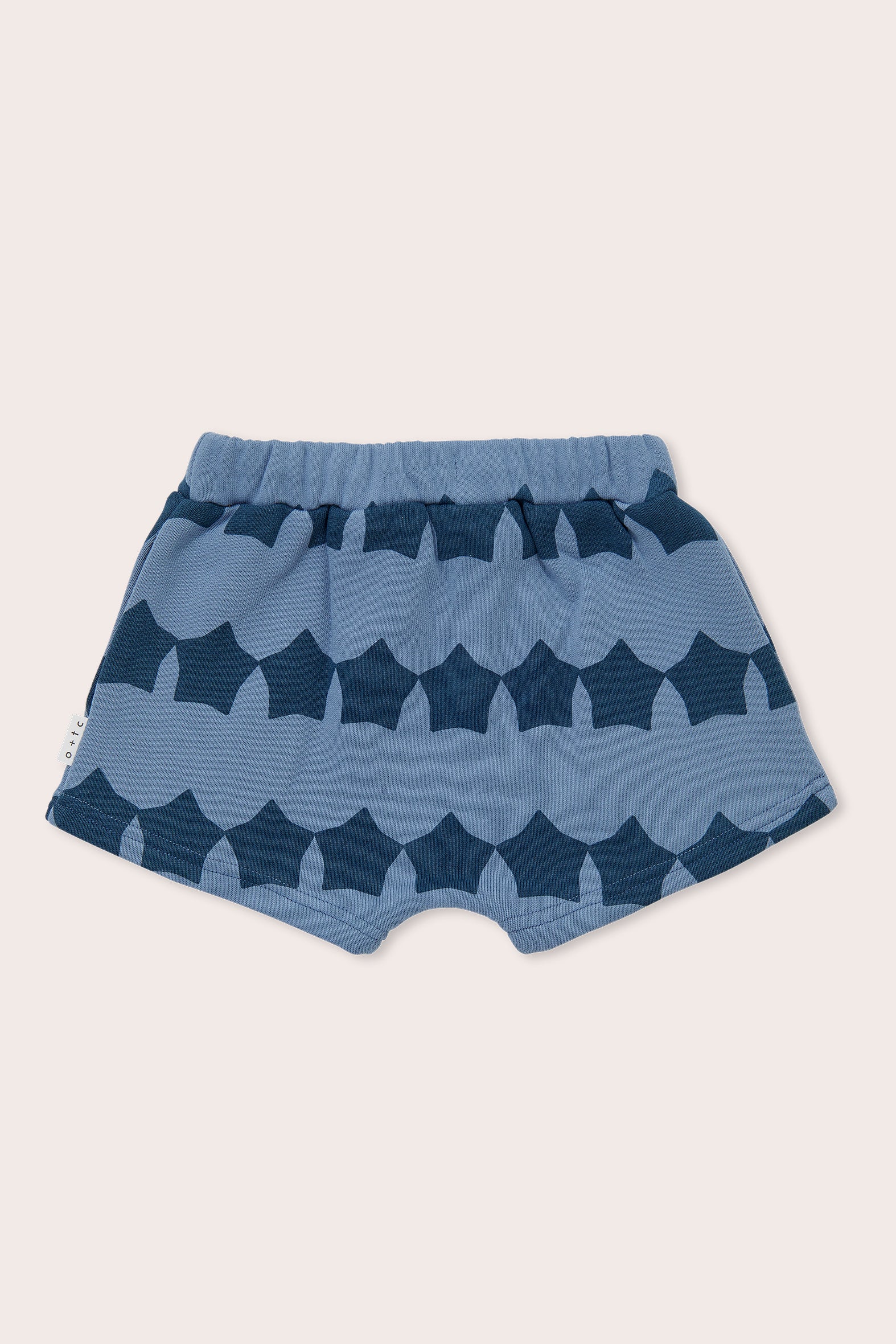 Introducing the Midnight Supernova Shorties by OLIVE + THE CAPTAIN – a delightful pair of blue toddler shorts adorned with a charming scalloped wave pattern. Crafted from 100% cotton, these shorts feature an elastic waistband for maximum comfort. Their simple and playful design makes them perfect for casual wear.