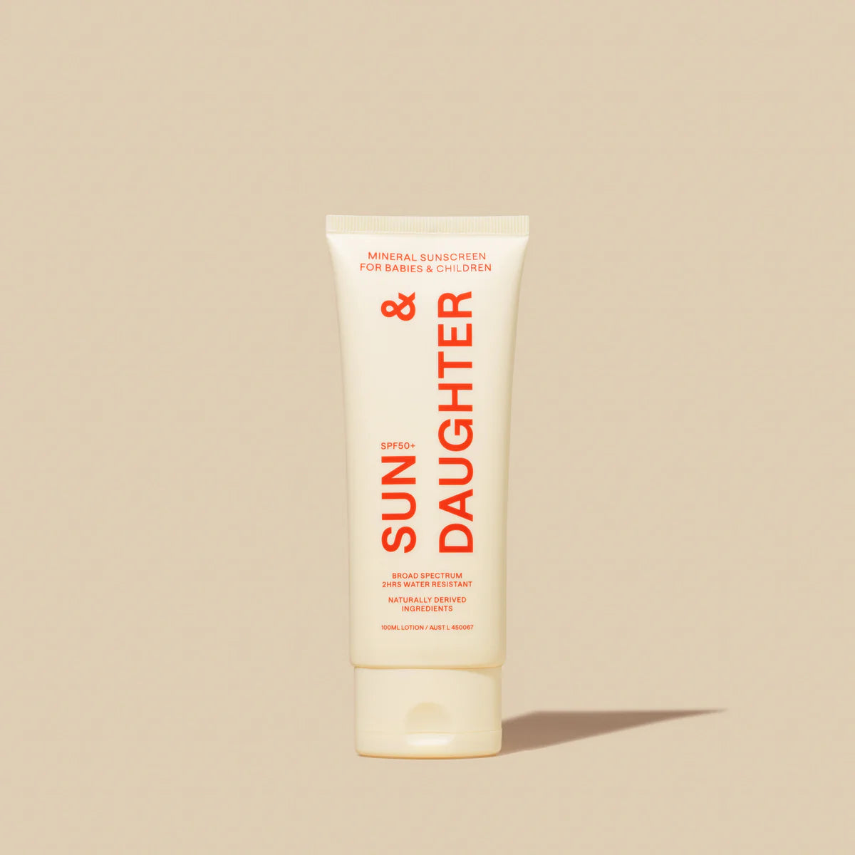 A beige tube of Sun & Daughter SPF50+ Mineral Sunscreen for babies and children is centered on a matching backdrop. The reef-safe packaging showcases vibrant orange branding, emphasizing SPF 50+ protection for delicate young skin.