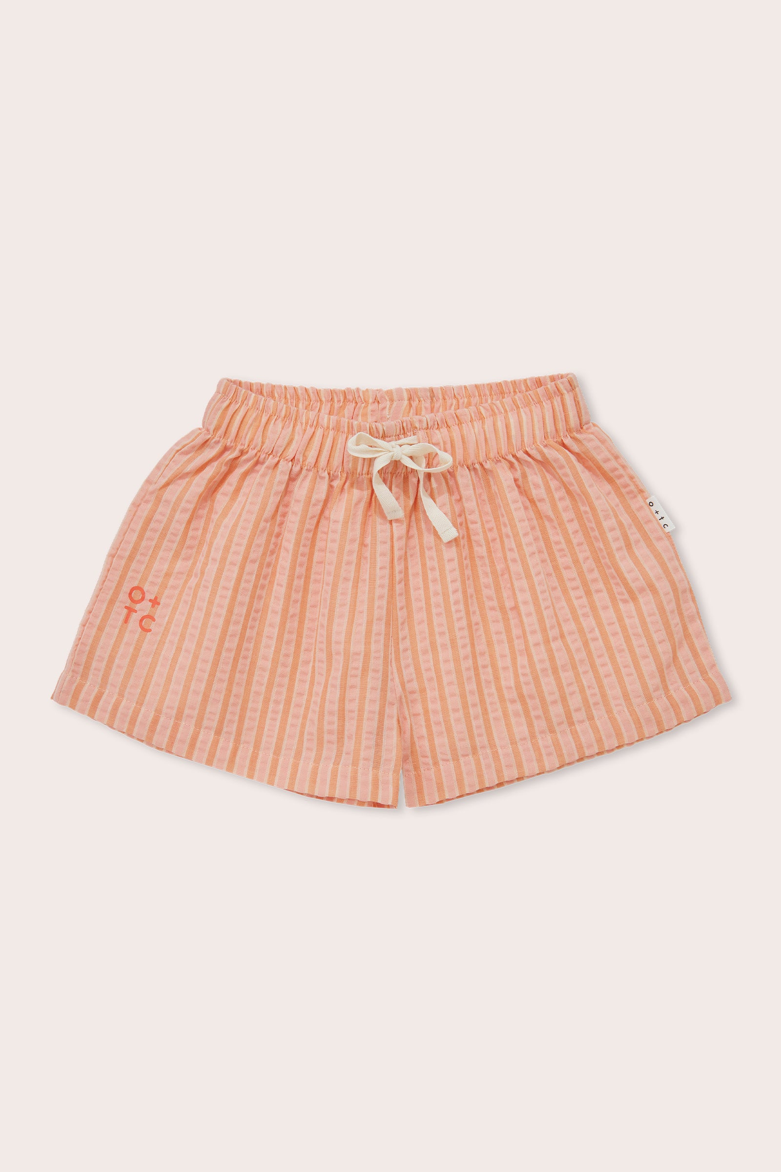 The Cantaloupe Wide Shorts by OLIVE + THE CAPTAIN are peach-colored, mid-thigh length shorts featuring a ribbed texture and an embroidered design on one leg. Made from a premium cotton polyester blend, these shorts come with a white drawstring and an elastic waistband for a comfortable fit.