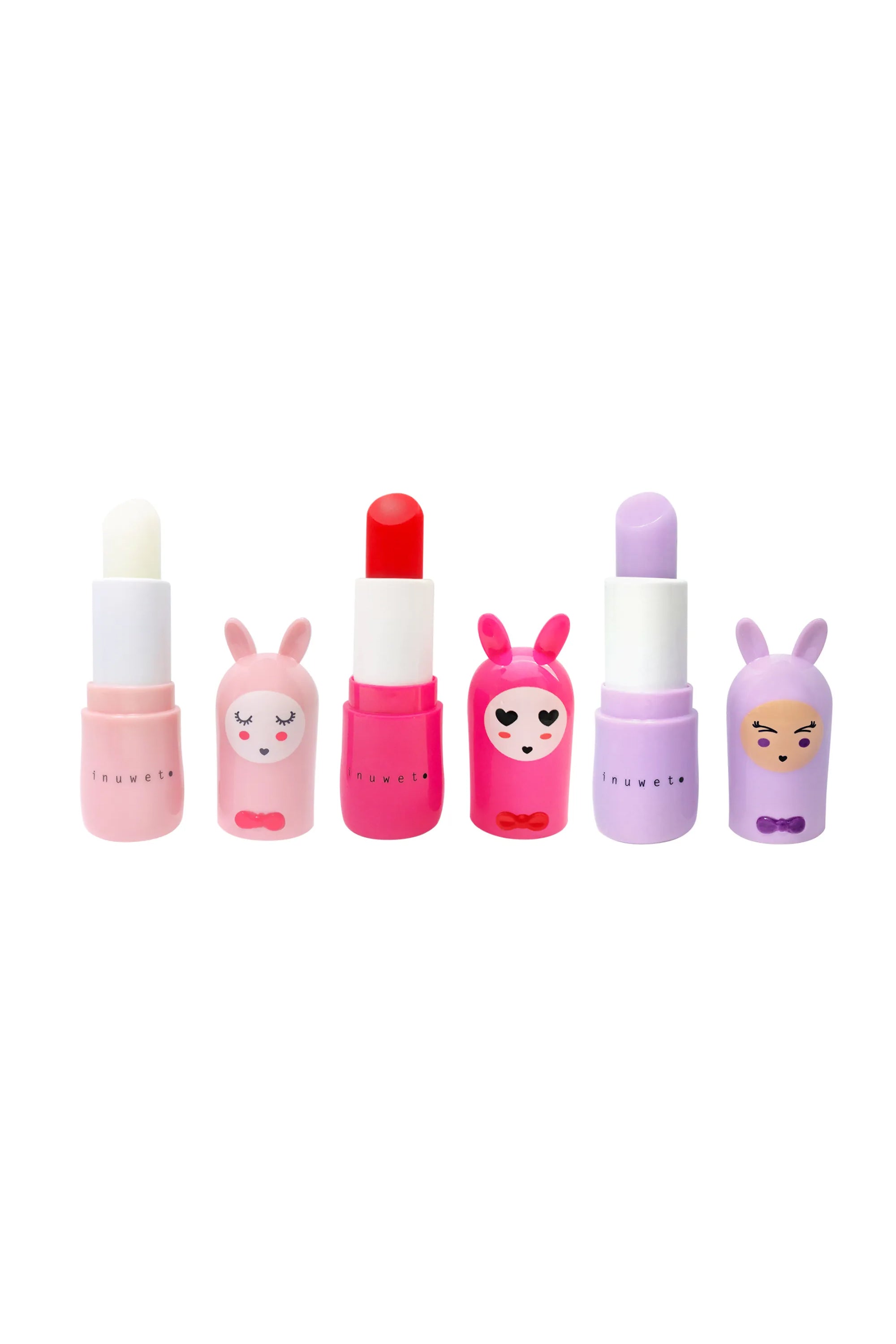 The Lip Balm Trio Friends Forever by INUWET features whimsical cartoon bunny-shaped caps in pink, red, and purple, each with a unique expression ranging from sleeping to smiling. These colorful, vegan lip balms are cruelty-free and paired with matching lip balm colors against a plain white background.