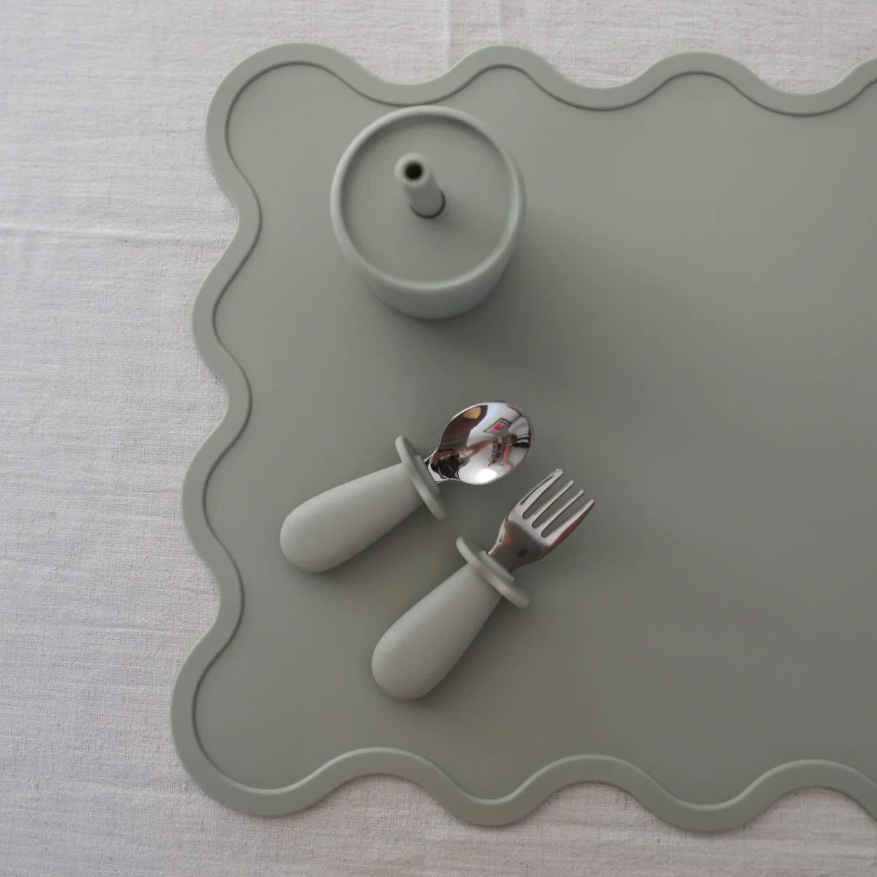 Wiggly place mat in oyster with kids fork, spoon and smoothie cup placed on it.