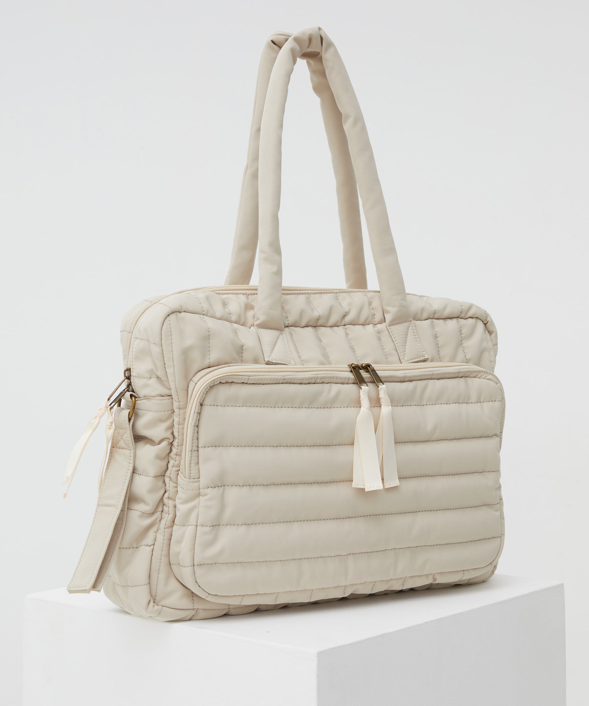 PHILÉ baby bag in cream on a 45 degree angle.