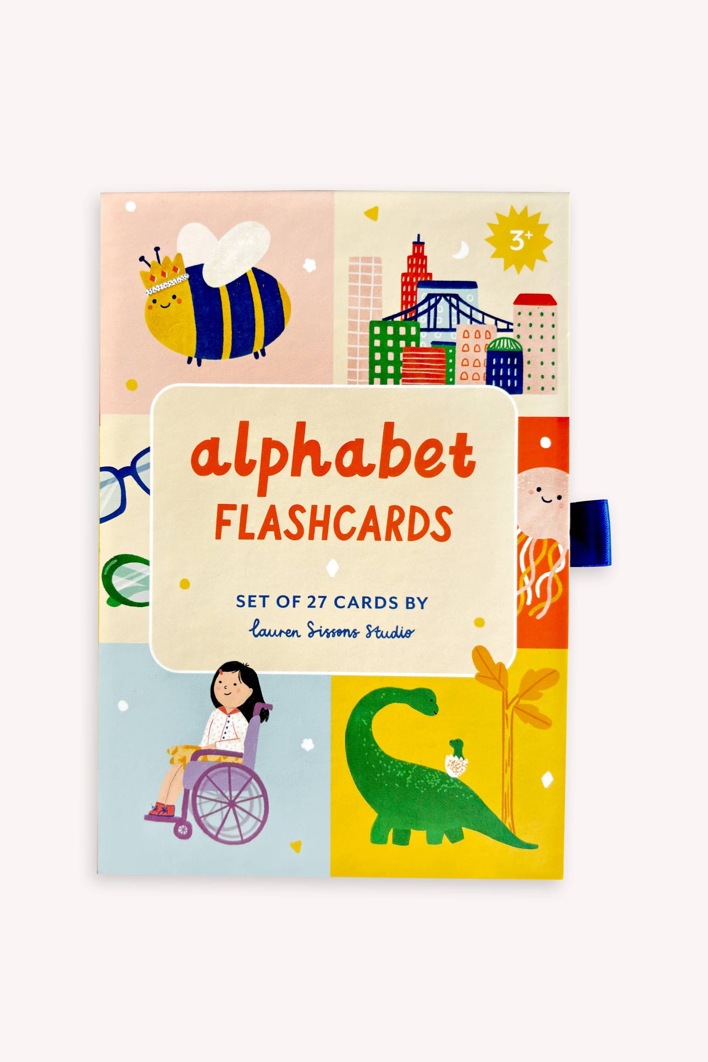 The LAUREN SISSONS STUDIO A-Z Illustrated Alphabet Flashcards is a colorful box of flashcards designed for children aged 3 and above. The set contains 27 laminated flashcards featuring playful illustrations, including a bee, a cityscape, a pair of glasses, a child in a wheelchair, a dinosaur, and a child holding a plant – perfect as children's educational toys.