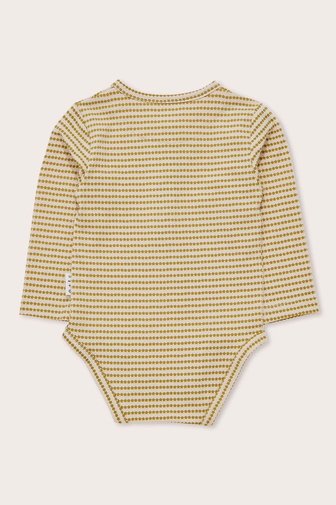 The Mini Stars Long Sleeve Bodysuit by OLIVE + THE CAPTAIN is displayed from the back. This white and mustard yellow baby bodysuit features a small, repetitive pattern and is made of soft cotton terry. It includes a round neckline and convenient snap buttons at the bottom for easy diaper changes.