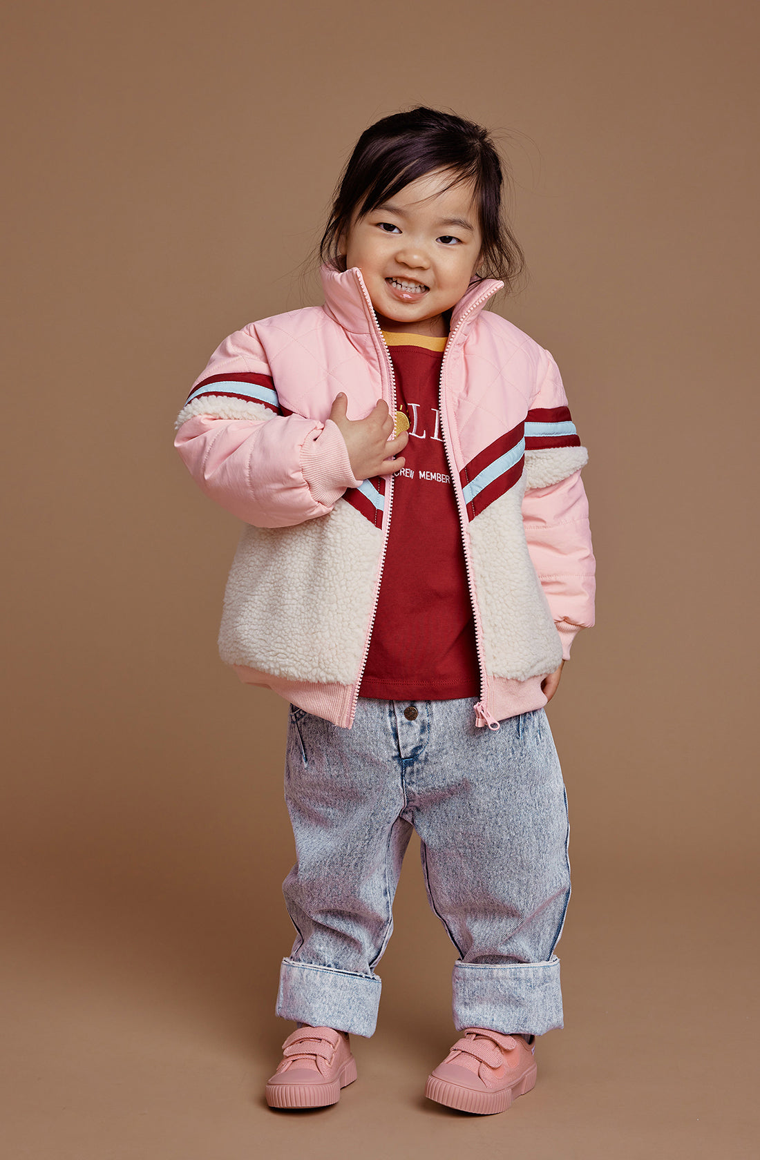 A young girl wearing the kobe shearling jacket in tulip pink. in 