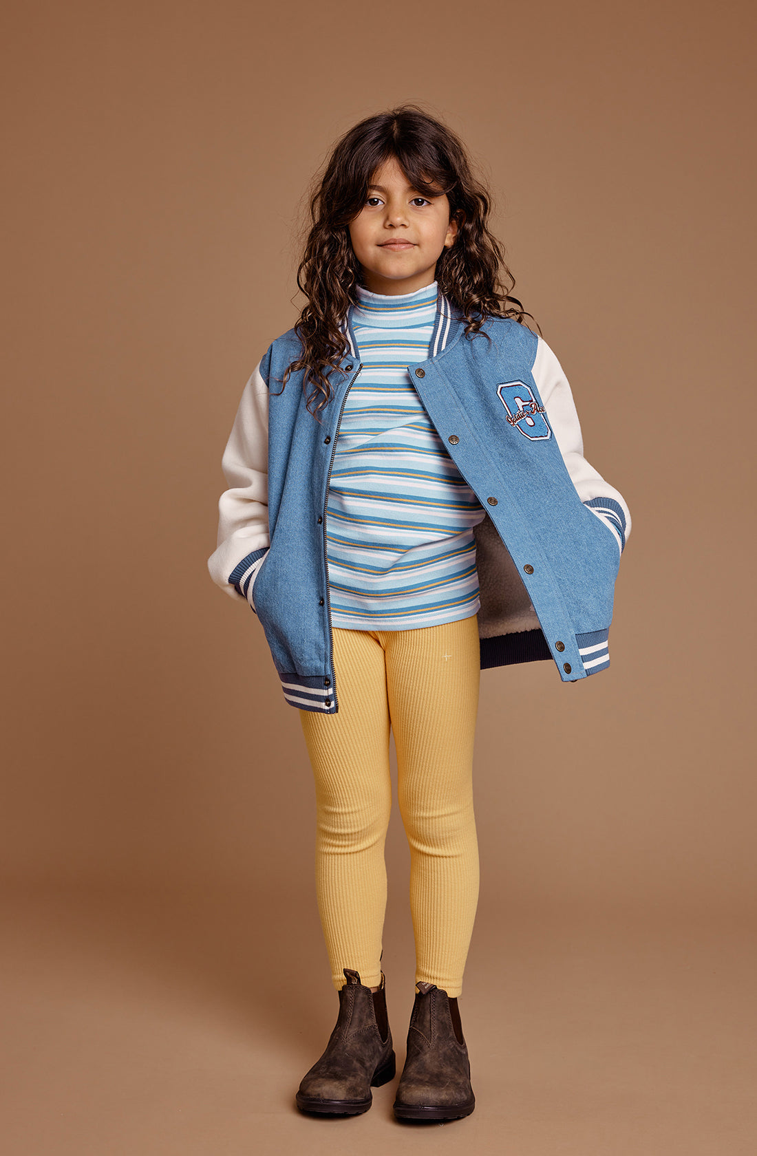 A young girl wearing the GOLDIE + ACE  Sky Stripe Embroidered Skivvy Sky/Gold.