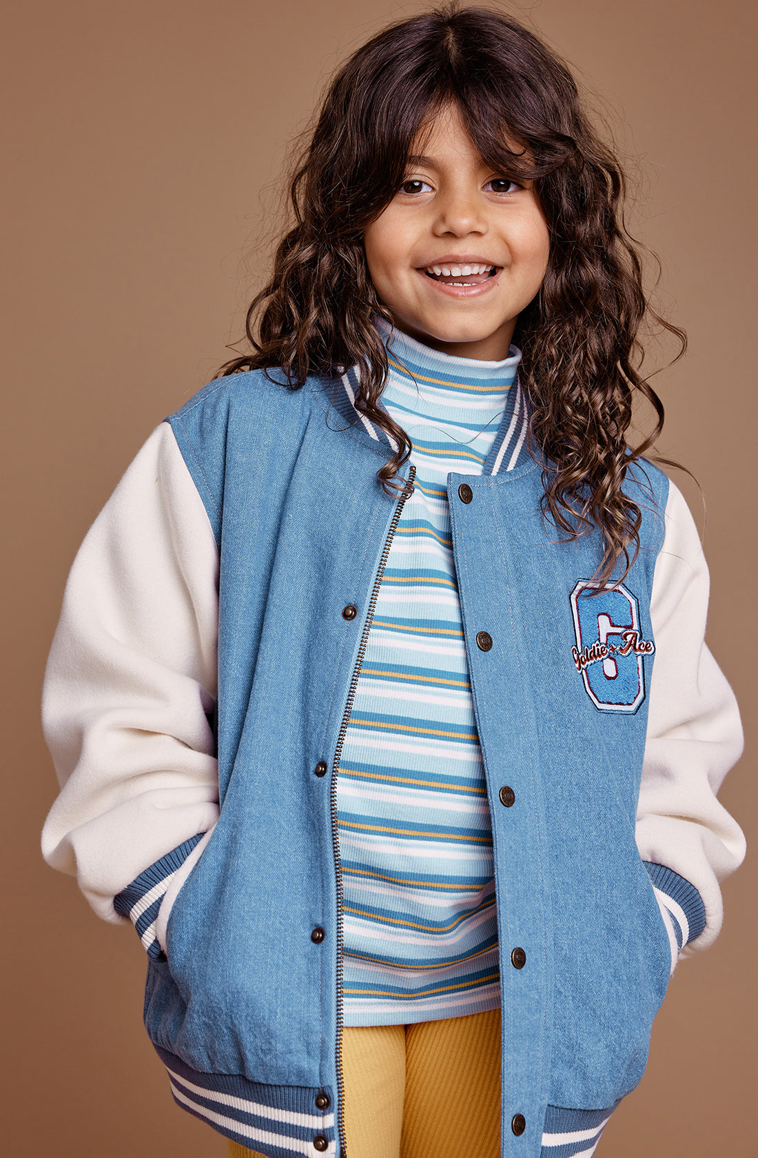 A young girl wearing the GOLDIE + ACE  Sky Stripe Embroidered Skivvy Sky/Gold.