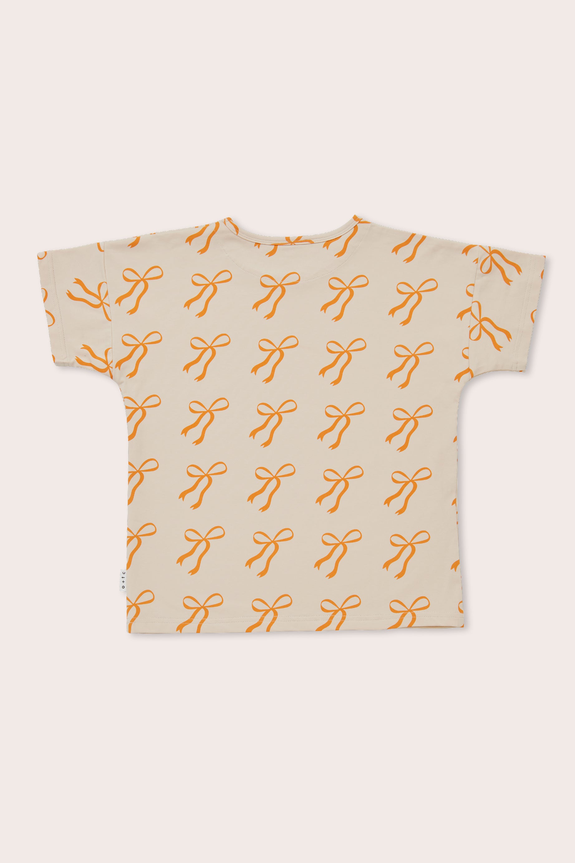 Here's a revised sentence using the given product data:
"Presenting the OLIVE + THE CAPTAIN Cream Bows Relaxed Fit Tee, a short-sleeved t-shirt in beige featuring an all-over print of orange bows in a repetitive pattern. Made from a premium cotton blend, the shirt is displayed flat with its back side facing up.