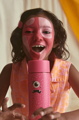 Girl with open mouth and pink face paint holding frankster Piper