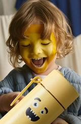 Smiling boy with yellow face paint holding frankster  Splash
