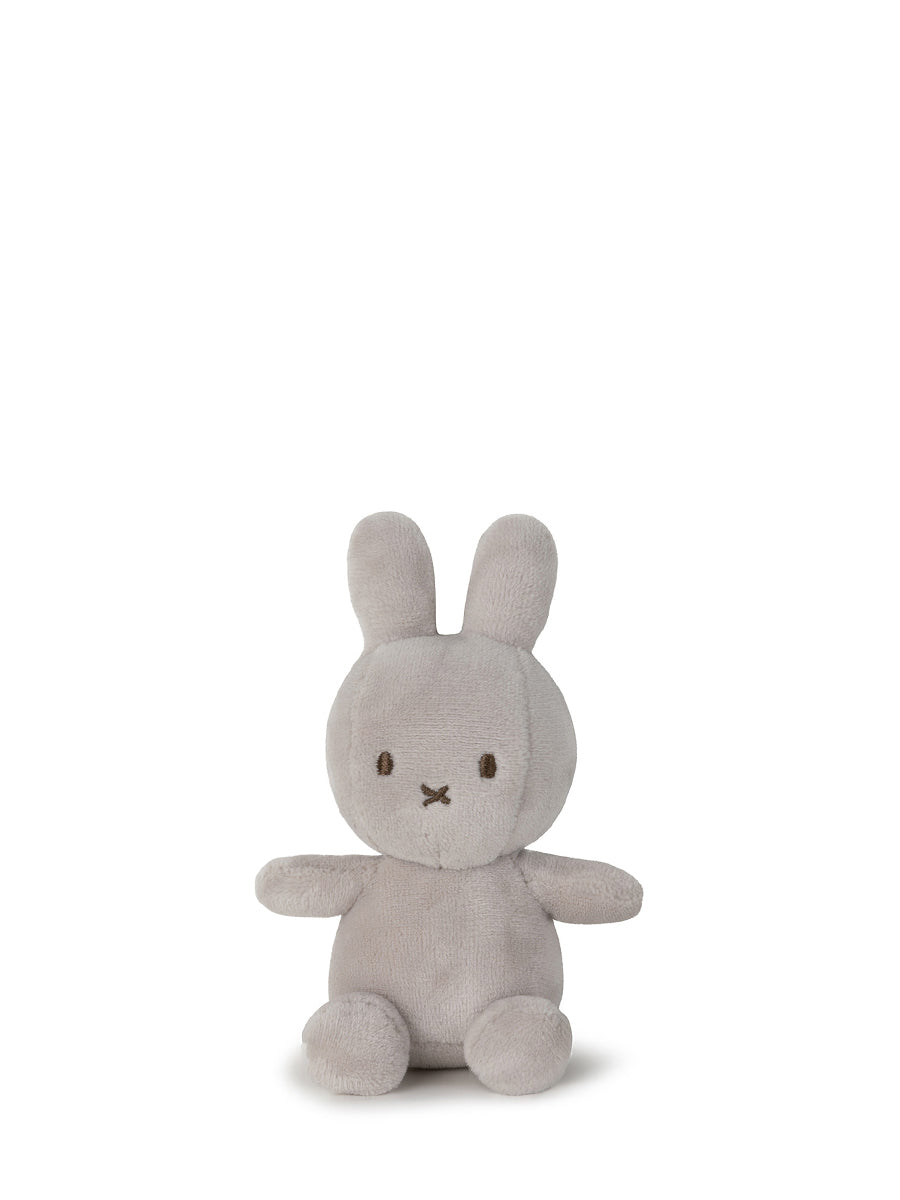 The Lucky Miffy in Giftbox Grey 10cm from BON TON TOYS X MIFFY is a soft, plush bunny toy handcrafted with recycled polyester. It sits upright against a plain white background, showcasing its muted grey color. The rabbit features long ears, round black eyes, and a small "X" shaped nose and mouth. Its simple and minimalist design gives it an irresistibly cute and cuddly appearance.