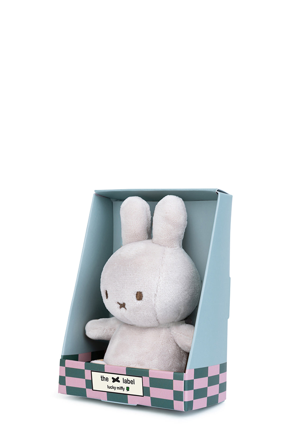 A small, plush bunny toy called "Lucky Miffy in Giftbox Grey 10cm" from the brand BON TON TOYS X MIFFY is displayed in light blue packaging with a checkerboard pattern at the bottom and a label that reads "the x label lucky milky 9." Handcrafted from recycled polyester, the light gray bunny features black eyes and a small, brown, "x" shaped mouth.