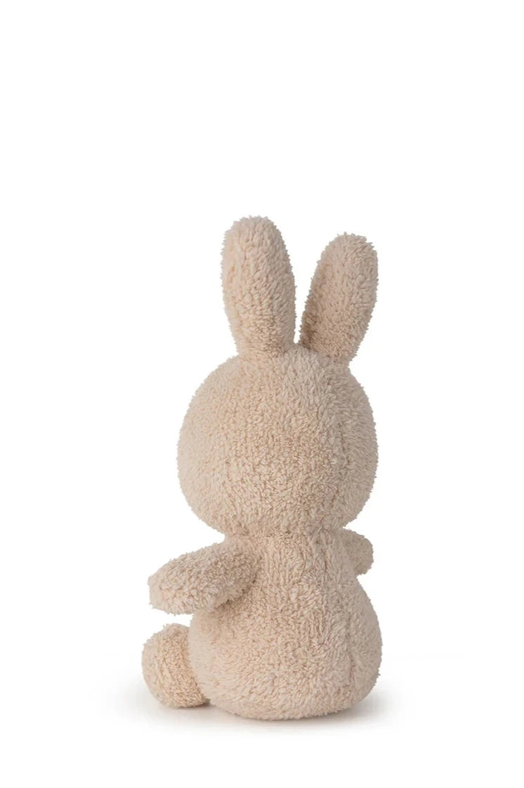 The BON TON TOYS X MIFFY "Miffy Sitting Terry Beige 23 cm" plush sits with its back to the camera, highlighting its two long ears and round body—the perfect baby gift against a plain white background.