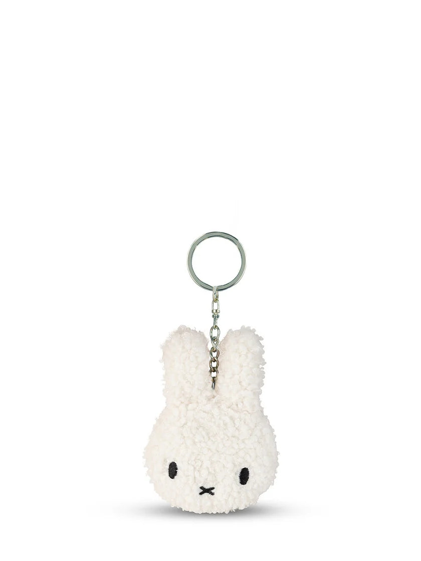 The Bon Ton Toys x Miffy Flat Keychain Tiny Teddy Cream features a cute bunny head design with long ears, stitched eyes, an X-shaped mouth, and a metal keyring—ideal as a sustainable backpack accessory.