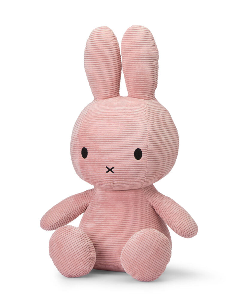 A Miffy Sitting Corduroy Pink 70 cm bunny plush toy by BON TON TOYS X MIFFY is sitting upright. It has long ears, black round eyes, and a small "X" shaped mouth. The ribbed texture of the fabric adds to the plush toy's appeal. The bunny exudes a soft and cuddly appearance, making it a perfect plush gift.