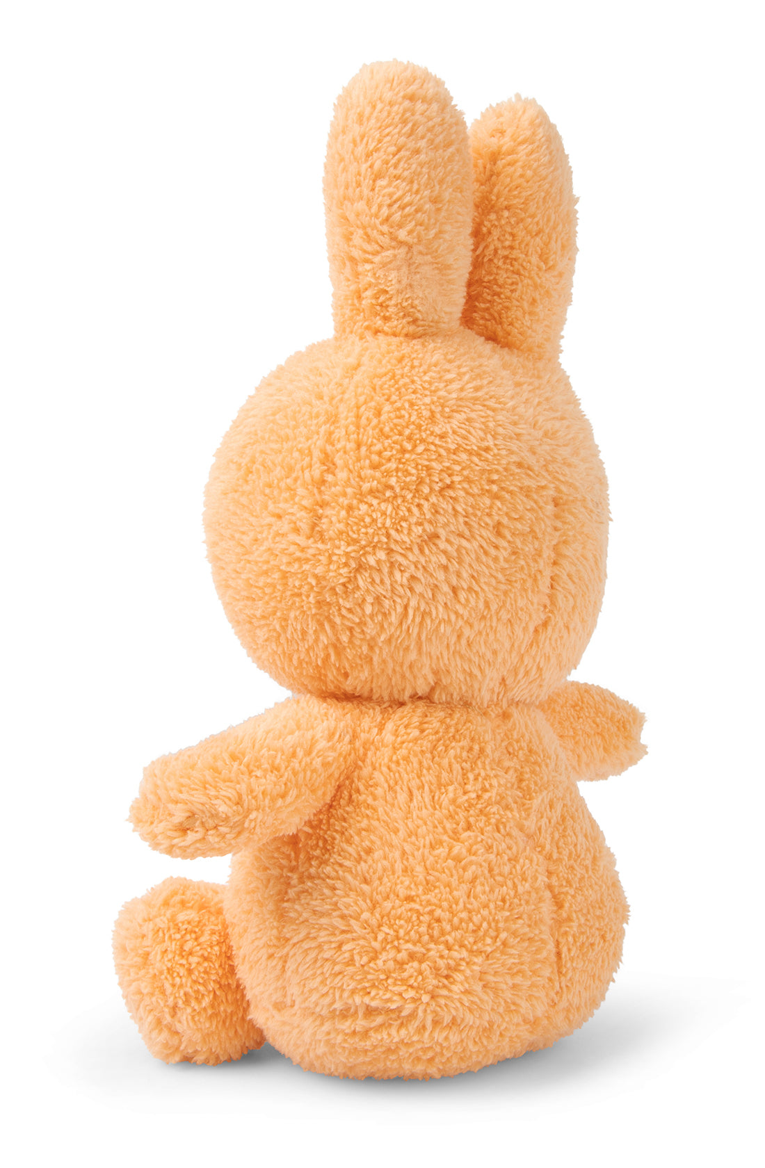 A soft, plush orange bunny toy viewed from the back. Handcrafted with care, the Miffy Sitting Terry Soft Orange 23 cm by BON TON TOYS X MIFFY features two large, upright ears and small outstretched arms while sitting down. Its fluffy texture gives it a cozy and cuddly appearance against a plain white background—the ultimate baby gift from the Miffy Terry Collection.