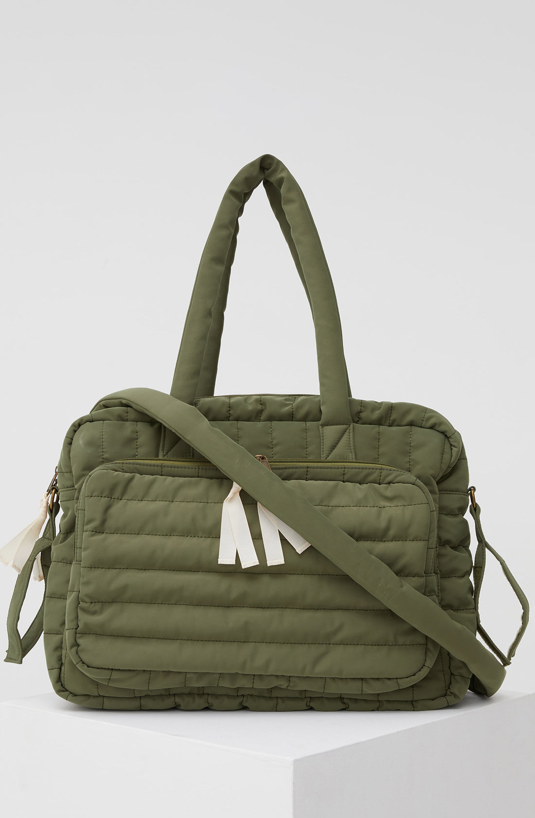 PHILÉ baby bag in khaki with strap across the front.