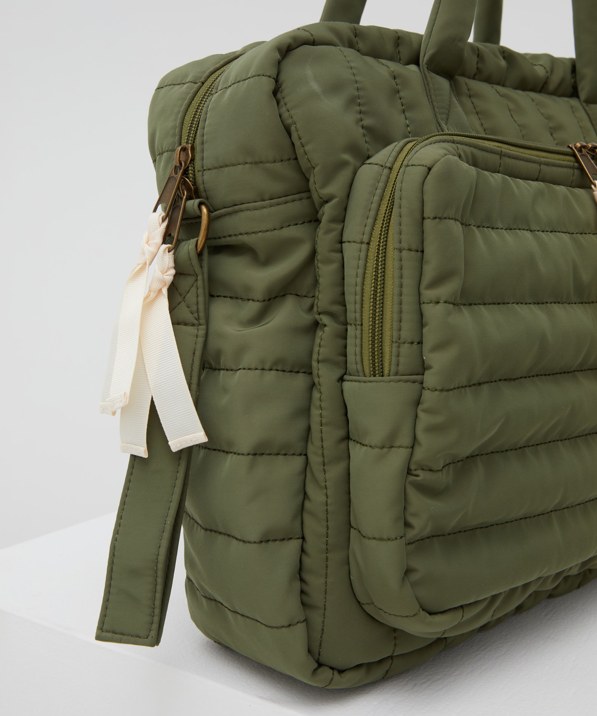 A close up of the PHILÉ baby bag in khaki on a 45 degree angle.