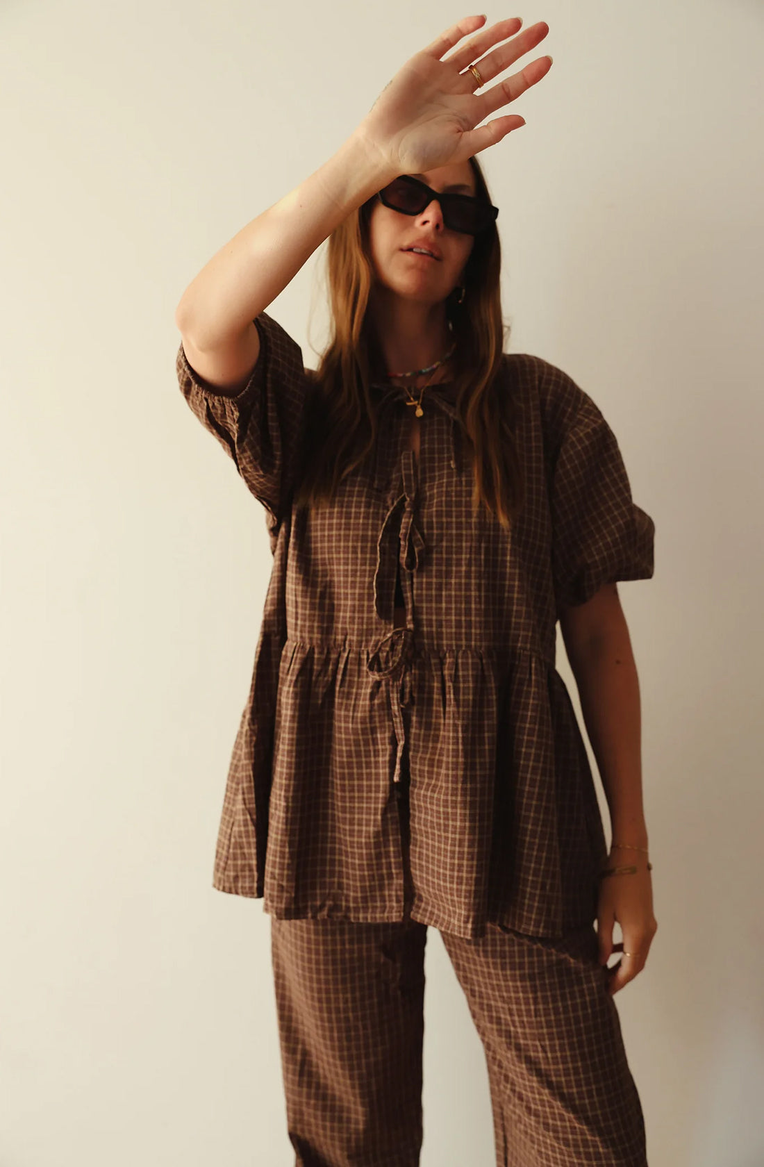 A women wearing the mama cami blouse and matching pant and black shades on.