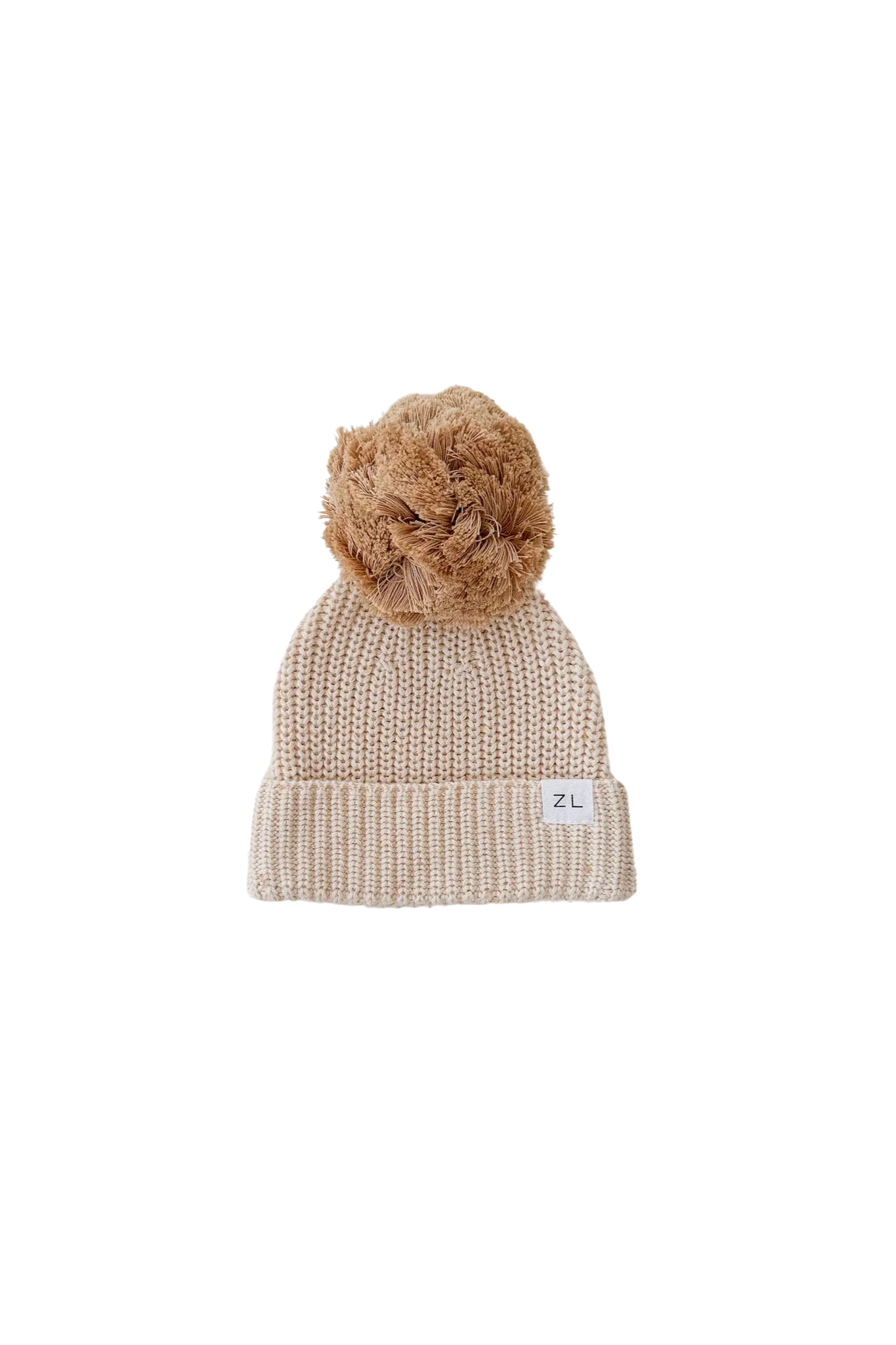 The Beanie Biscotti Fleck by ZIGGY LOU is a beige, chunky knit beanie adorned with a large, fluffy pom-pom on top. Its 100% cotton cuffed brim showcases a small white label with the initials "ZL" on the lower right side.