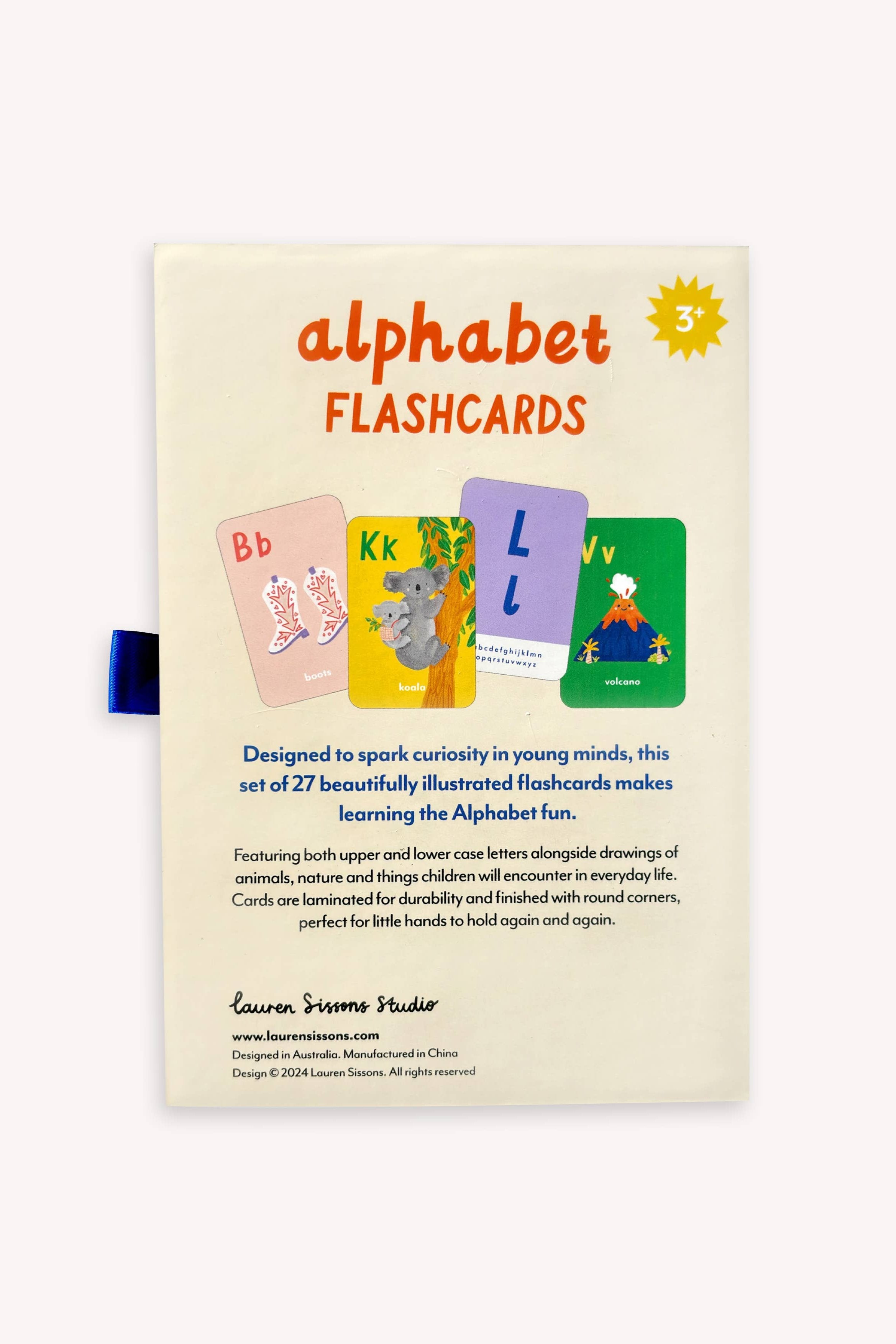 The image depicts the reverse side of a package labeled "A-Z Illustrated Alphabet Flashcards" by LAUREN SISSONS STUDIO. It showcases three sample laminated flashcards featuring the letters E, K, and L, each accompanied by relevant illustrations. The text emphasizes the product's features, benefits, and suitable age group (3+).