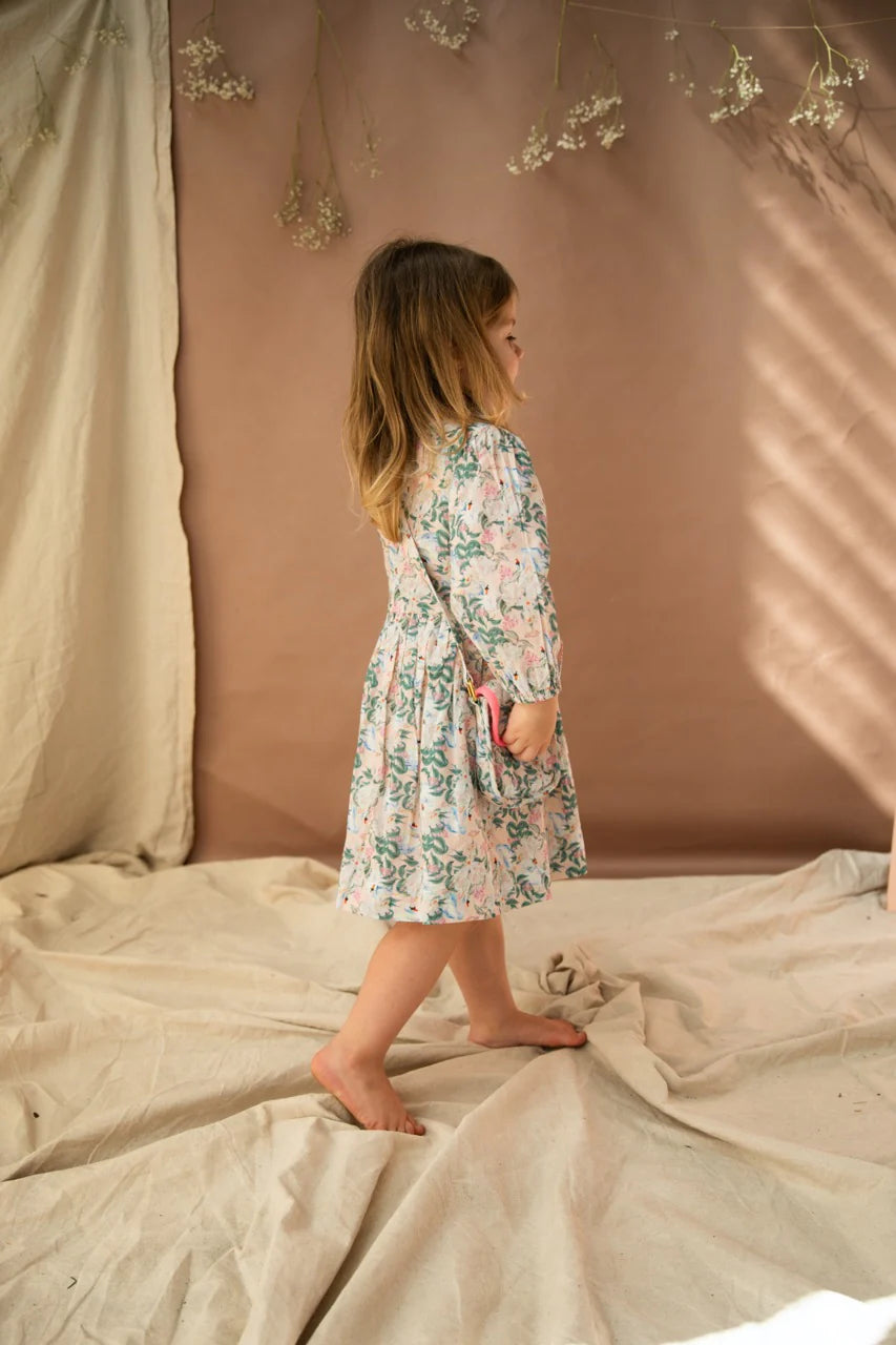 A young girl wearing the treasures bag with the hello gorgeous print. She is also wearing a dress in the same print. the girl is side on from the camera.