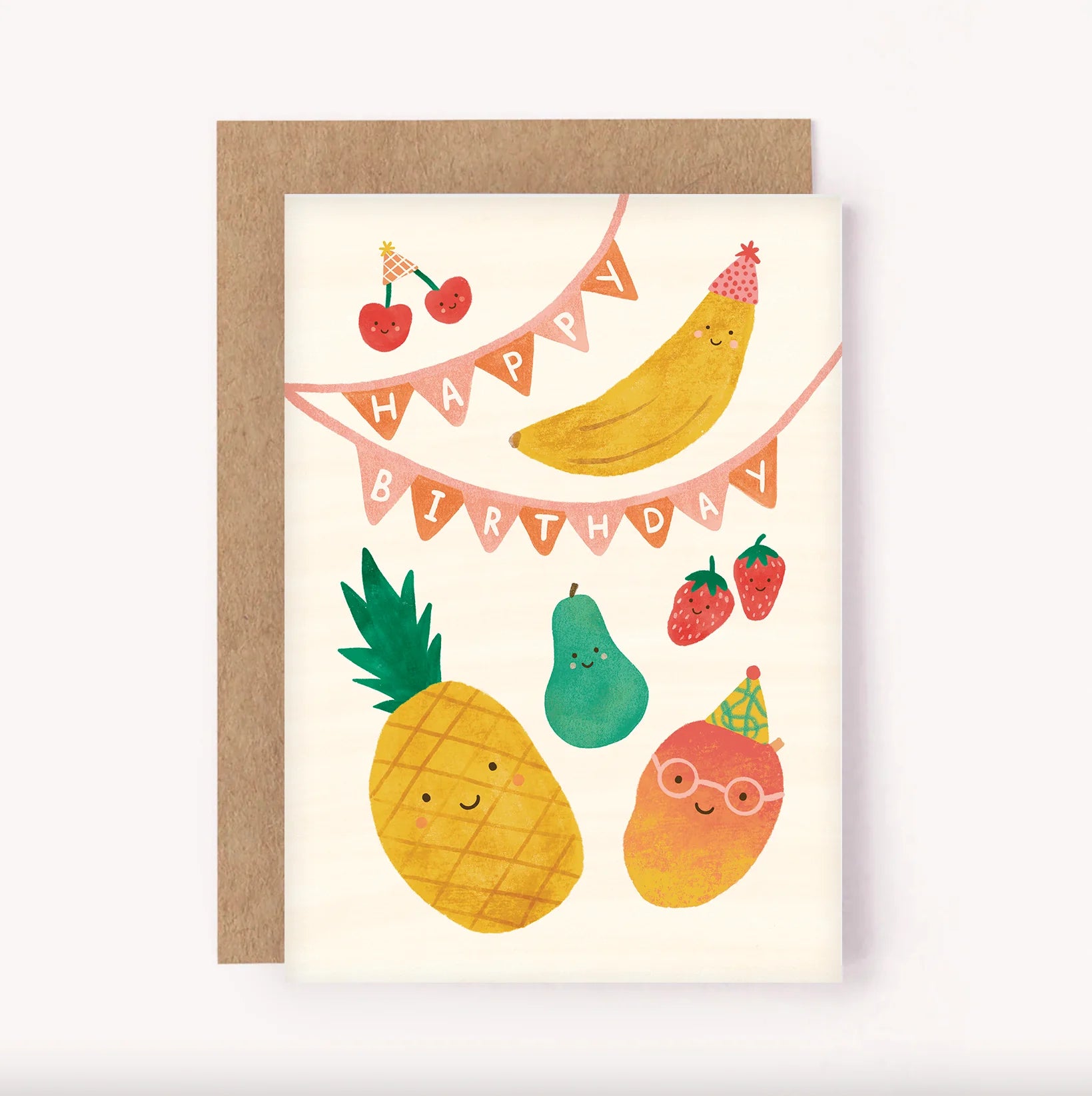 The Birthday Greeting Card "Fruit Party" from LAUREN SISSONS STUDIO is a cheerful children's birthday card featuring happy-faced fruit wearing party hats. The design includes a banana and cherries on a "Happy Birthday" banner, a pineapple, a pear, two strawberries below, and an orange with glasses and a party hat. The card comes with a brown envelope made from recycled paper.