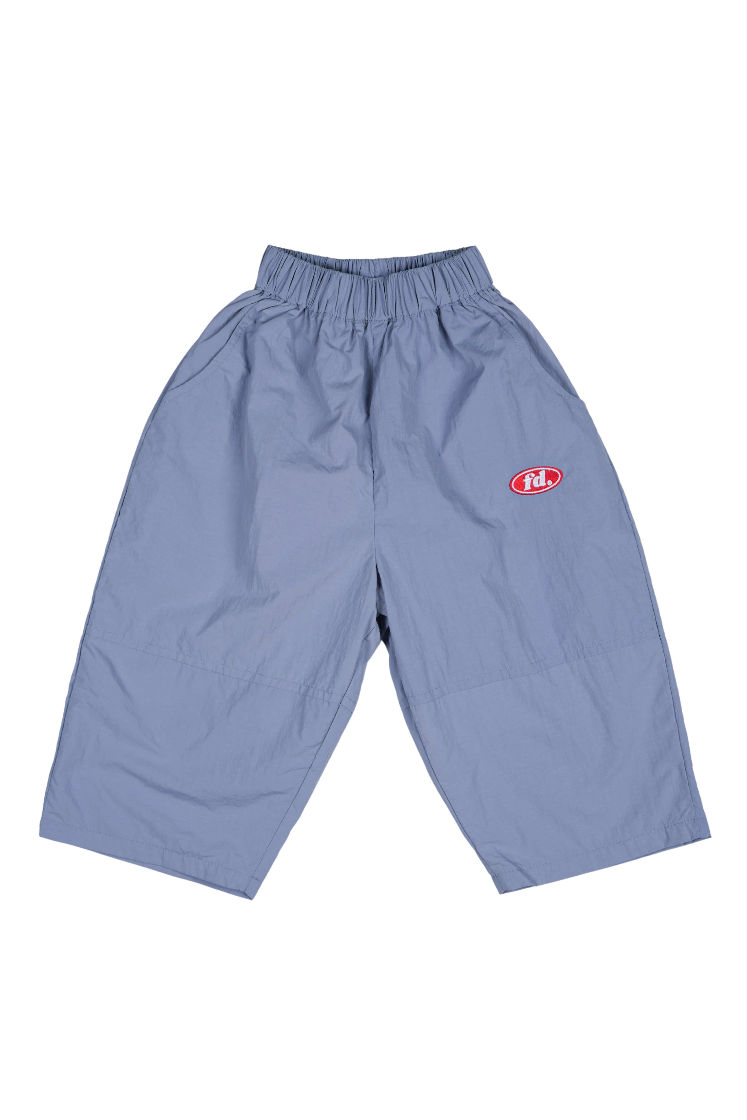 Franco's Dad ~ Tech Tracks Blue by FRANCO'S DAD are light blue, wide-legged pants made from waterproof material, with a stretch waistband and a red logo patch on the left thigh.