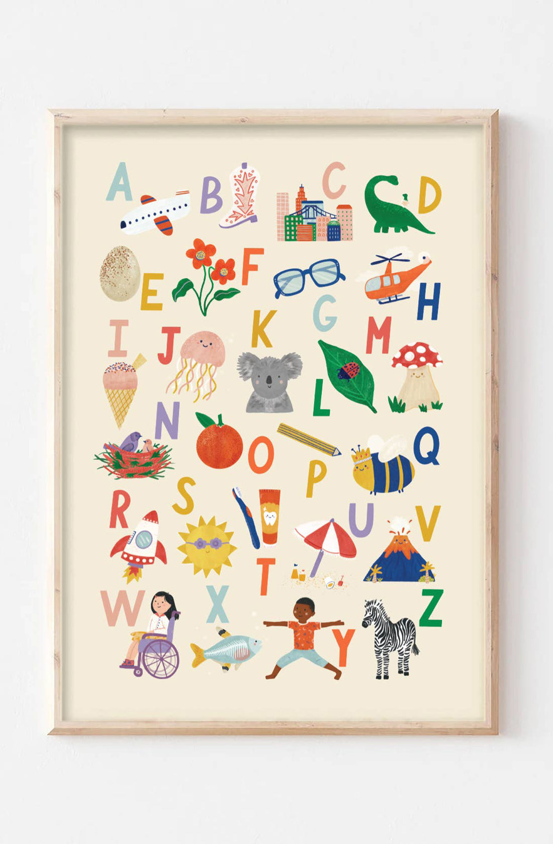 The Illustrated Alphabet Wall Art Print by LAUREN SISSONS STUDIO is a framed print showcasing beautifully illustrated letters from A to Z, each accompanied by corresponding images like an airplane for A, a zebra for Z, and a koala for K. This vibrant nursery decor adds delight to any children's room with its array of colorful objects and animals set against a white background.