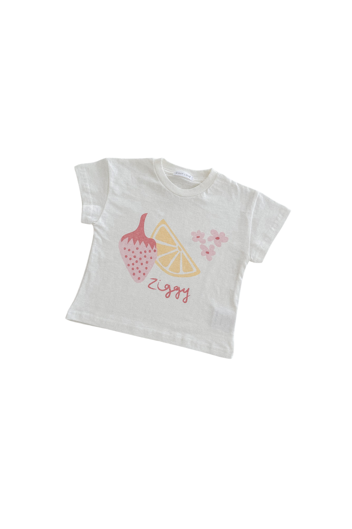 Introducing the Print Tee August by ZIGGY LOU: a white toddler t-shirt from the Summer Collections, showcasing vibrant prints of a strawberry, a lemon slice, and small bunches of cherries. Below the illustrations, "ziggy" is elegantly written in red script against a black background.