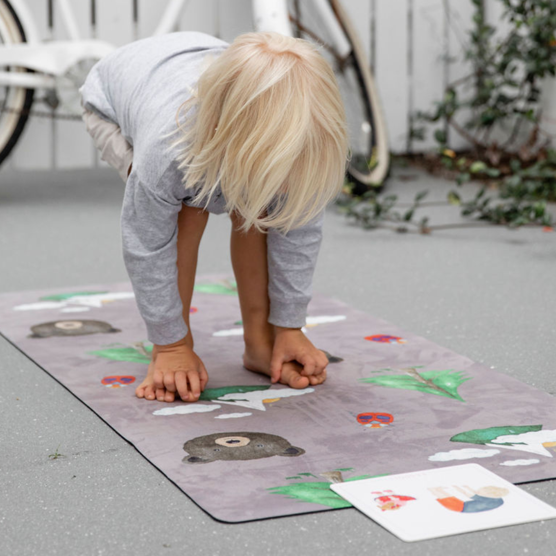 Young boy standing on a nature print kids yoga mat.