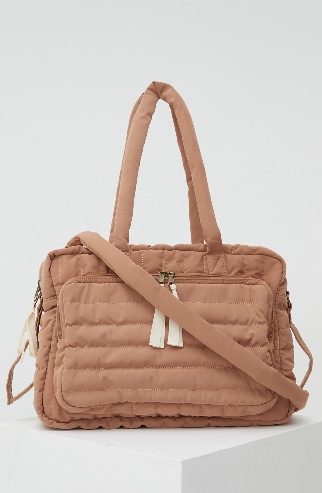 PHILÉ baby bag in terracotta with the strap across the front.