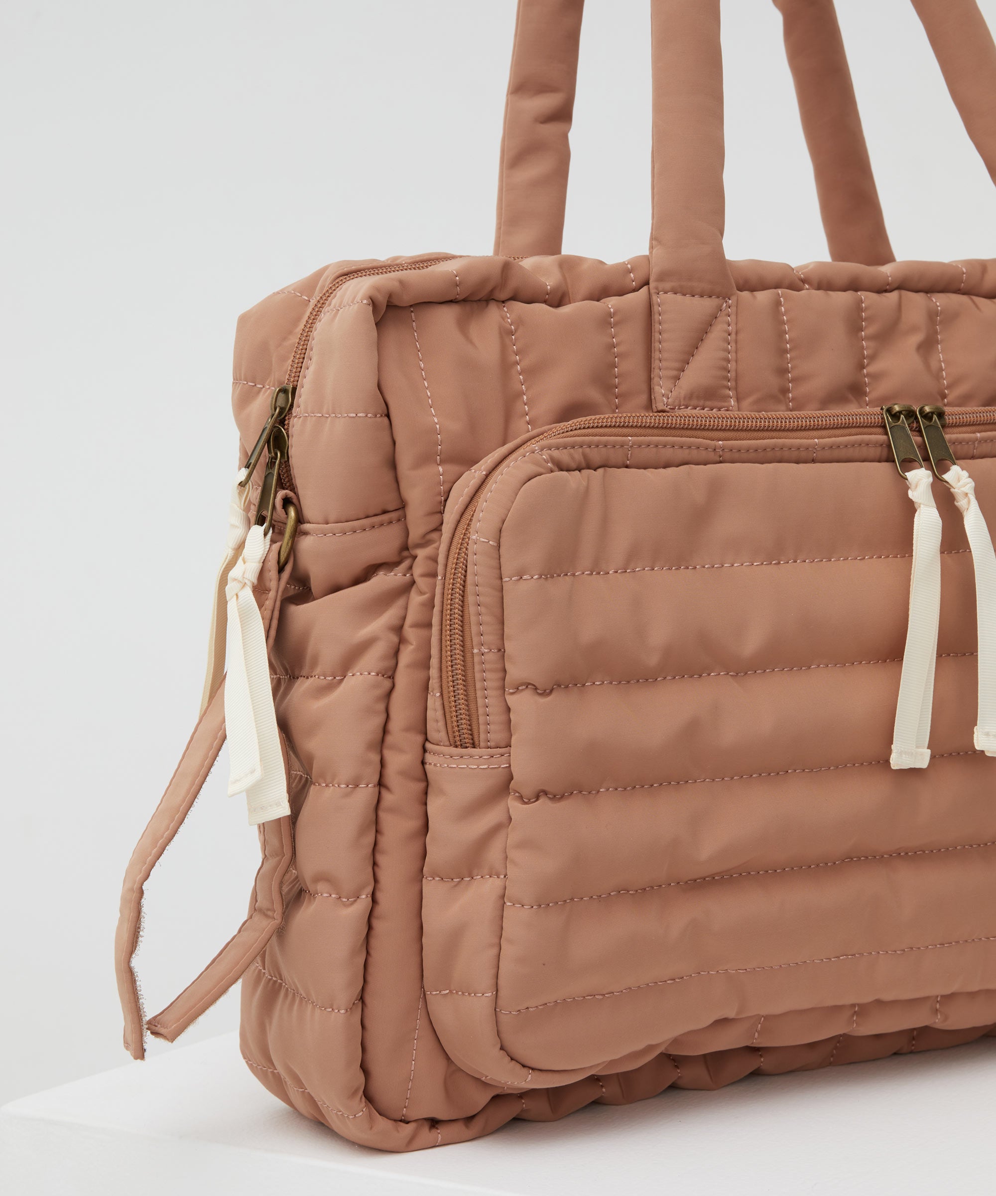 A close up of the PHILÉ baby bag in terracotta on a 45 degree angle.