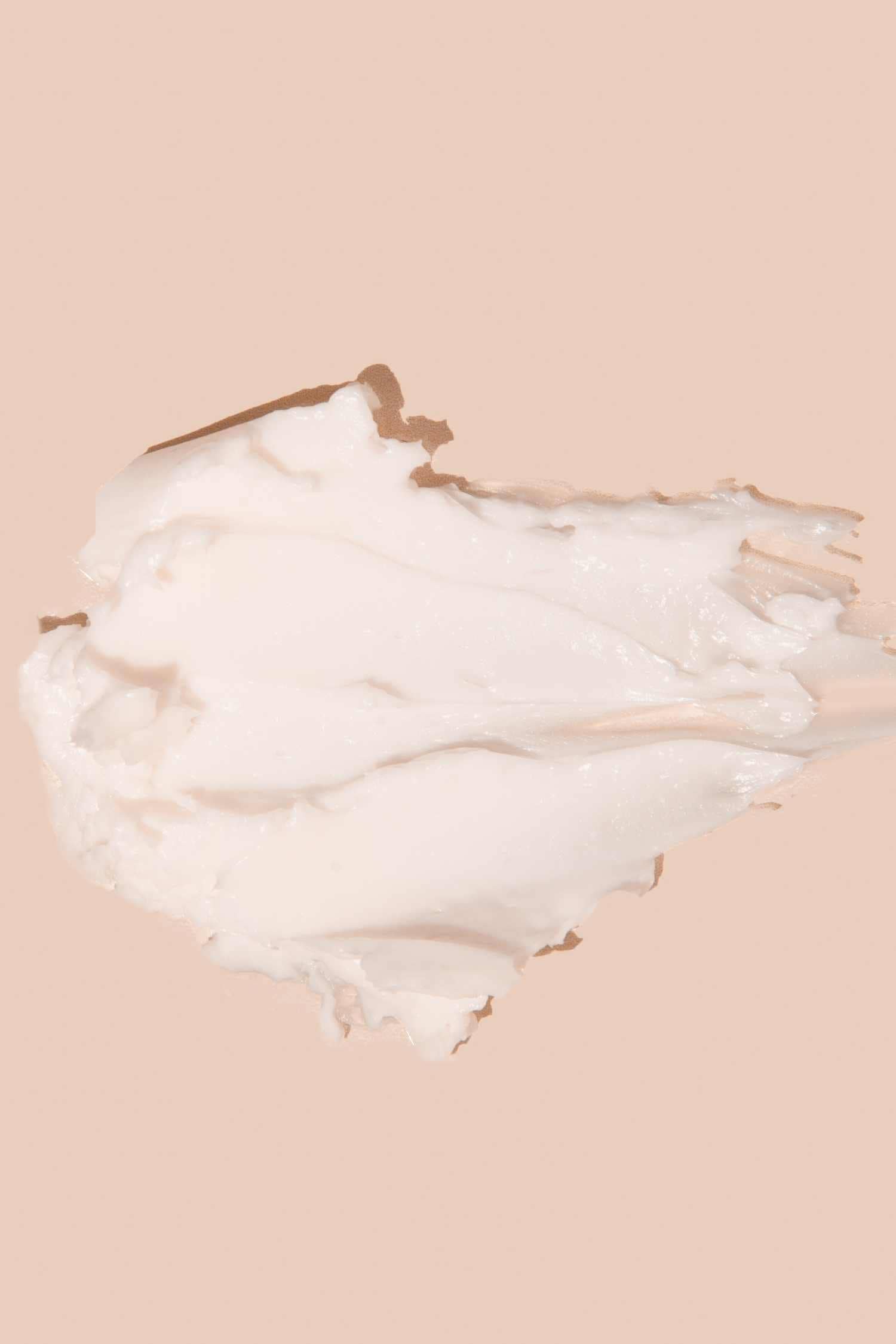 White lotion spread on light pink background