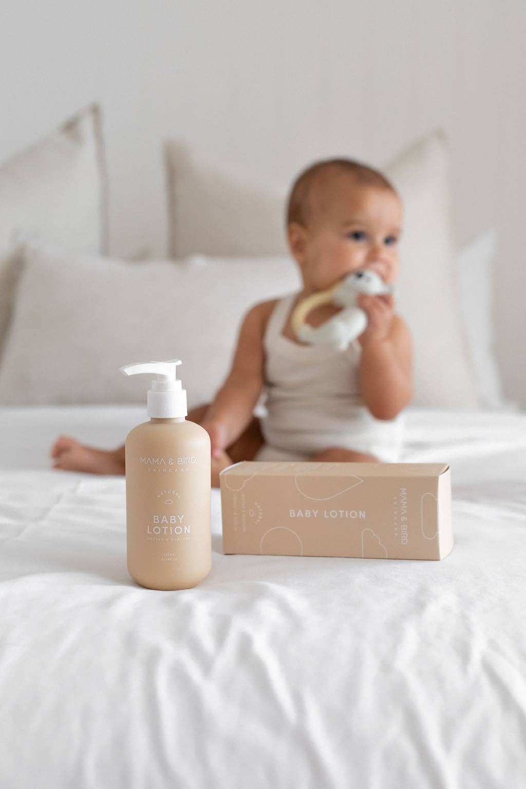 Mama and Bird baby lotion bottle and package in front of a baby.