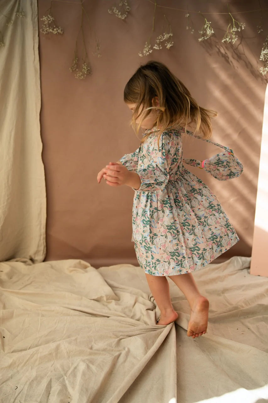 A young girl wearing the treasures bag in the hello gorgeous print. Shes also wearing a dress in the same print.