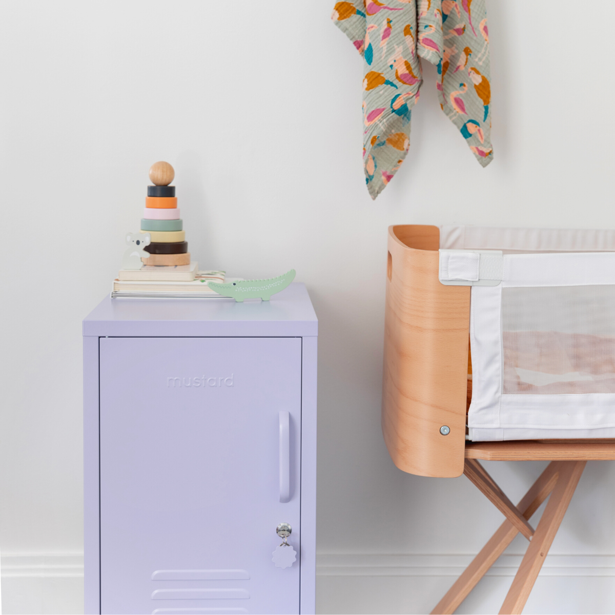 The shorty (to the left) locker in lilac next to a crib.