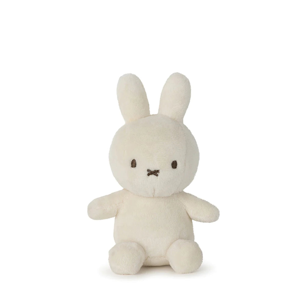 The Lucky Miffy in Giftbox Cream 10cm by BON TON TOYS X MIFFY is a charming white plush toy, handcrafted in the shape of a rabbit with long ears and a simple embroidered face. Made from recycled polyester, this delightful bunny sits upright against a white background, exuding an aura of luck and comfort.