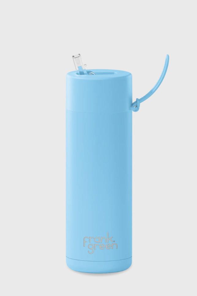 A tall, cylindrical, sky blue ceramic reusable bottle with a straw lid from FRANK GREEN. The bottle has a sleek, smooth design with "frank green" written in small gray letters near the bottom. This Frank Green Ceramic Reusable Bottle has a capacity of 595ml / 20oz.